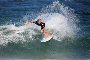 Surfer girl cutting in the waves.