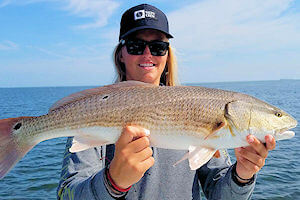 Yound lady angler holding a Red Drum.